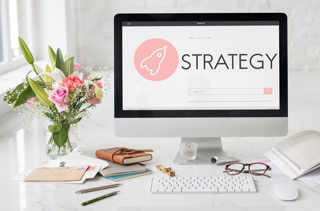 Desk with a monitor showing a strategy presentation